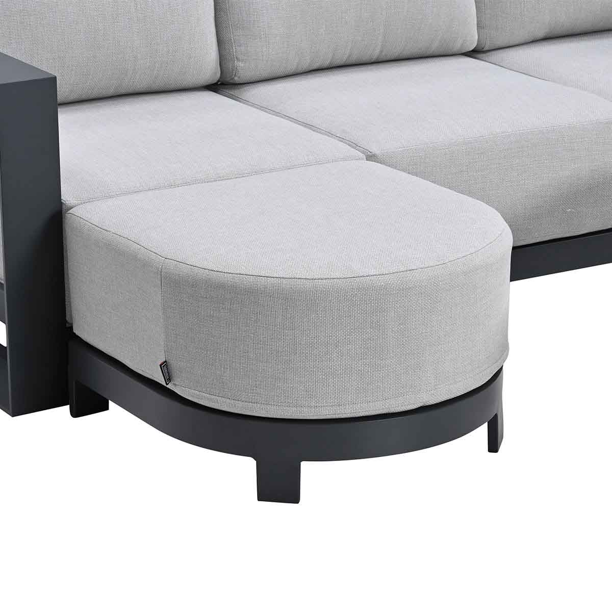 Gray upholstered stool with dark frame, part of a modular sofa.