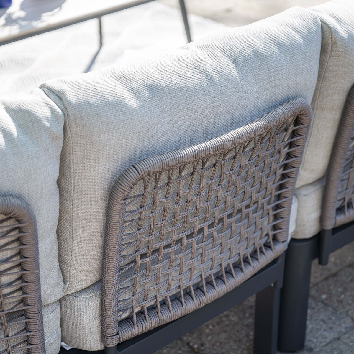 Gray wicker and cushions on a modern outdoor sofa.