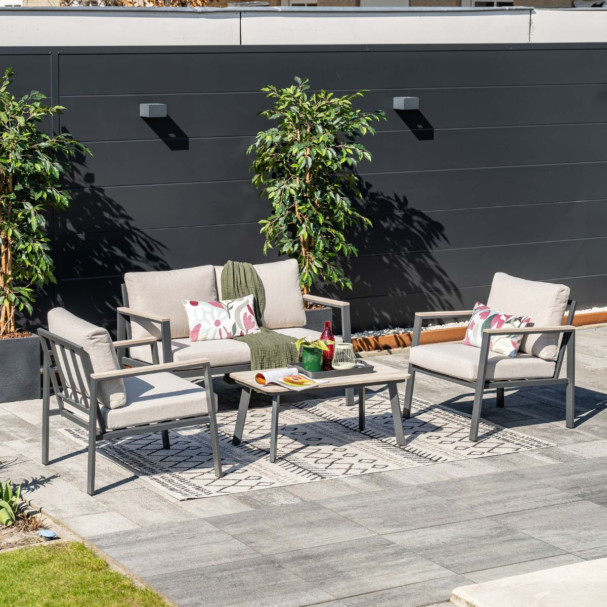 Outdoor lounge set with sofa, armchair, and coffee table on a patio.