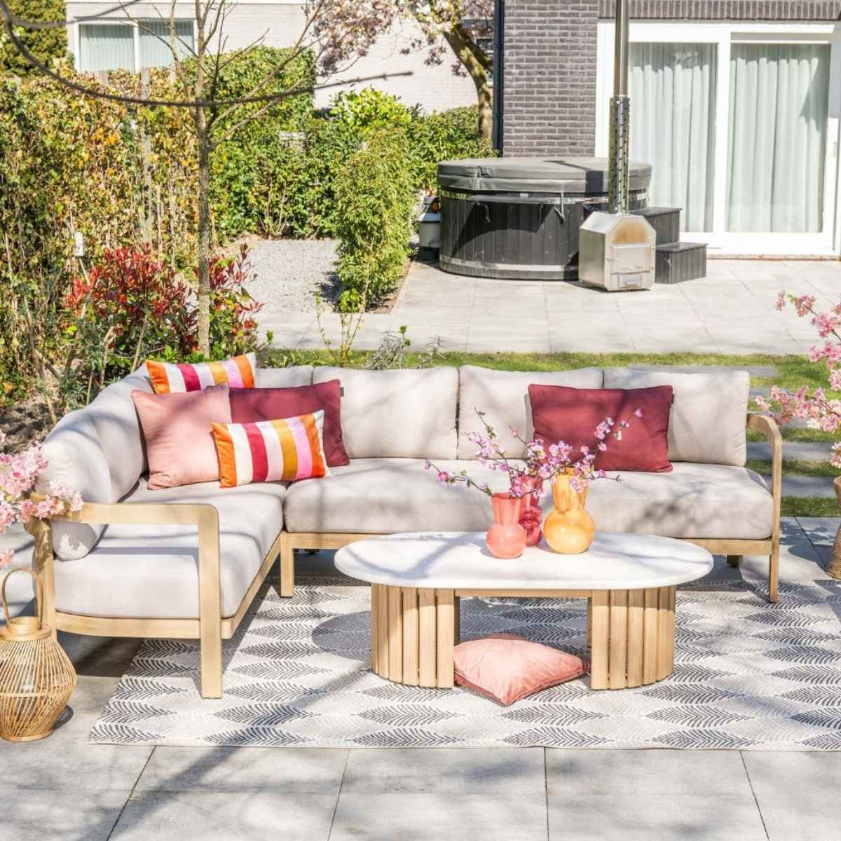 Buitenwoonruimte met bank, salontafel, verwarming en hot tub.
