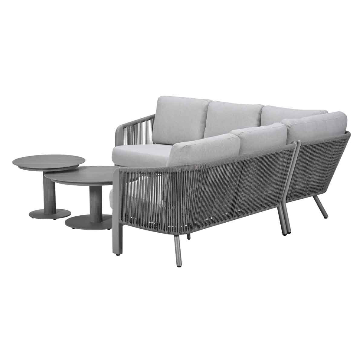 Gray sectional sofa with two round side tables.