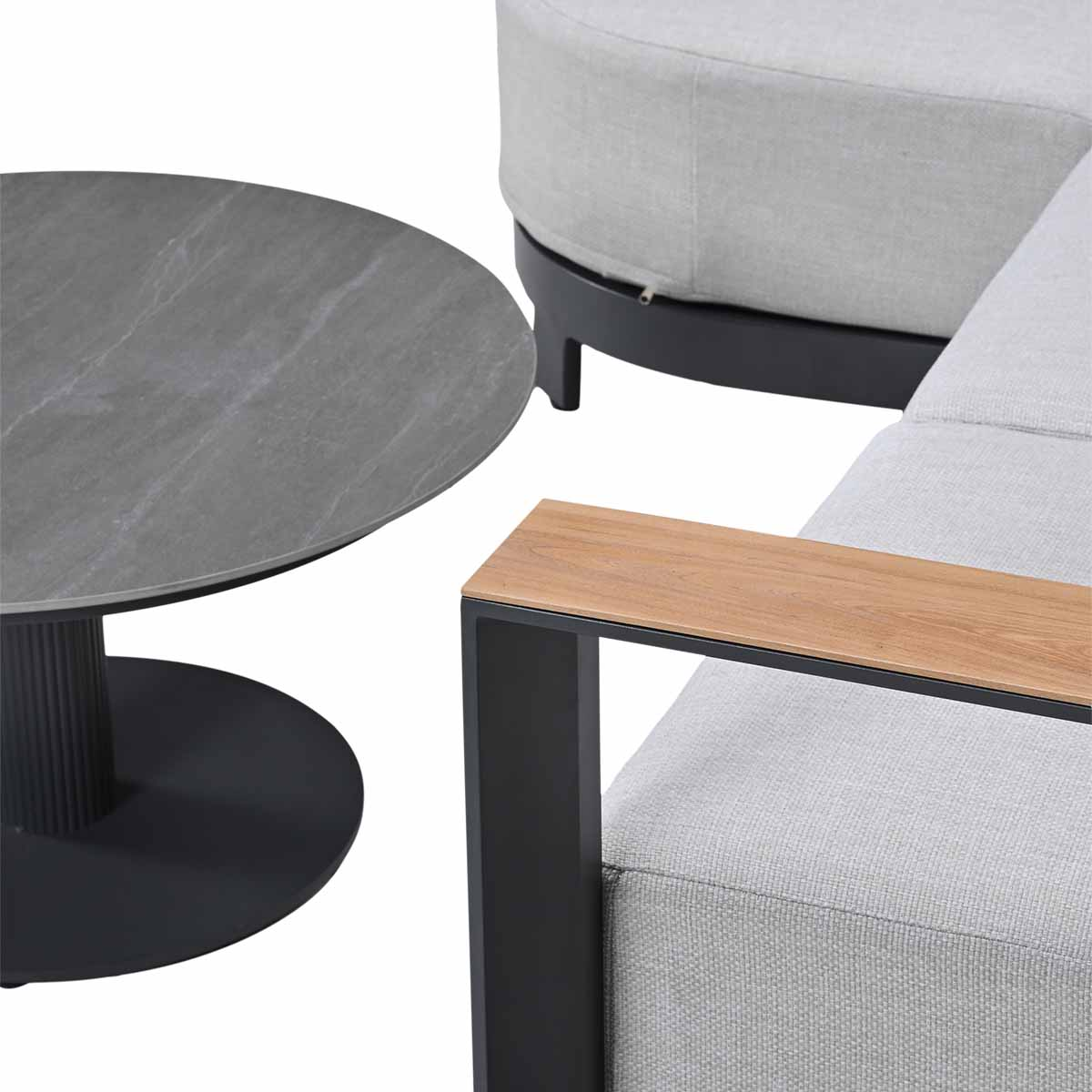 Gray round table next to a light gray sofa with wooden armrest.