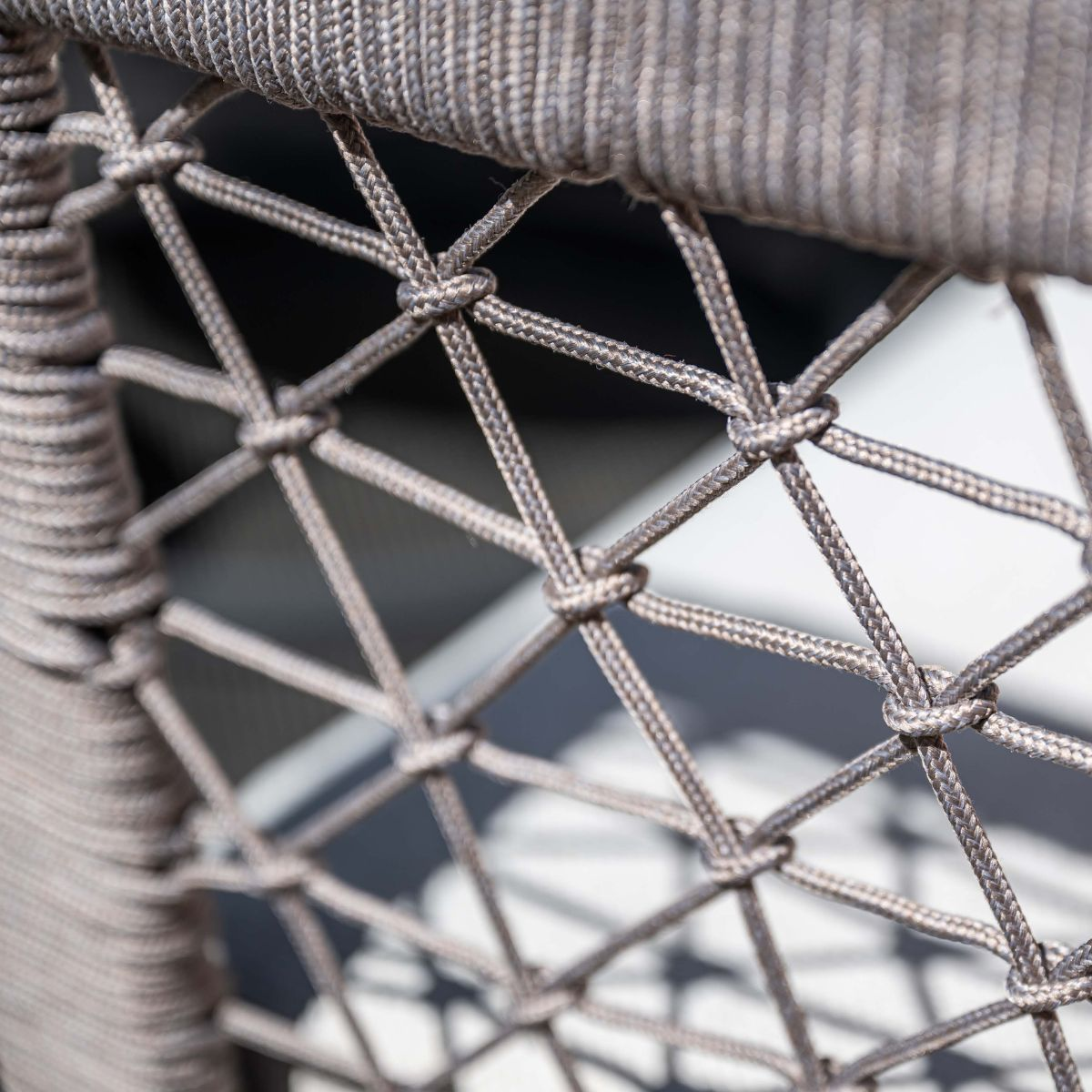 Gray rope weave forms a diamond pattern on a chair.