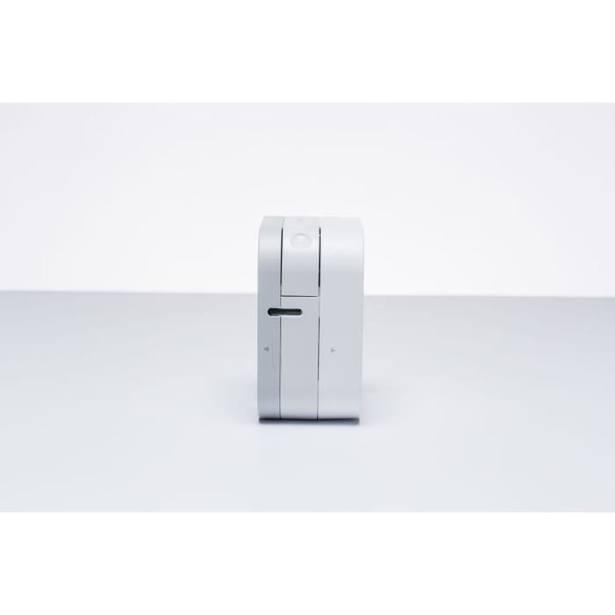 Un petit appareil électronique blanc et rectangulaire avec une fente.