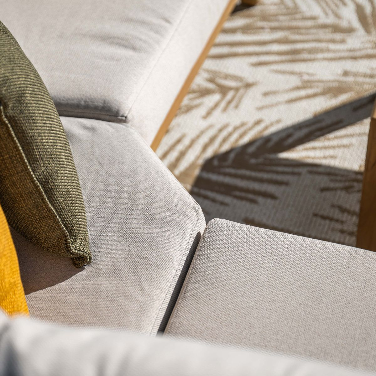 Gray outdoor furniture with cushions and a palm leaf patterned rug.