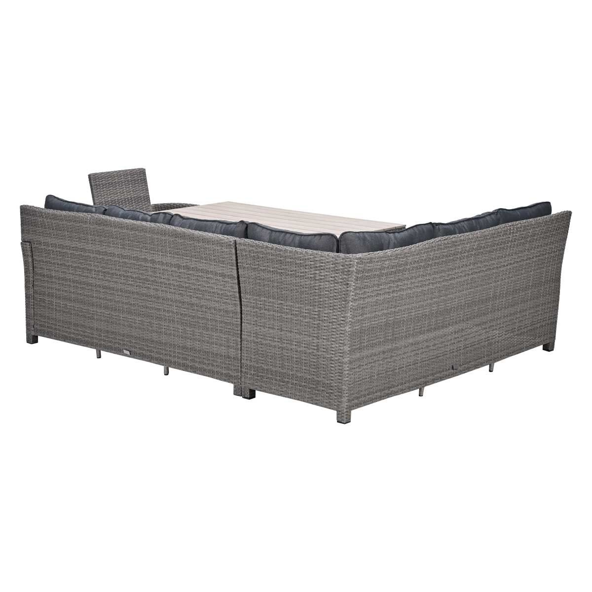 Grijze rotan hoekbank met grijze kussens en houten tafel.