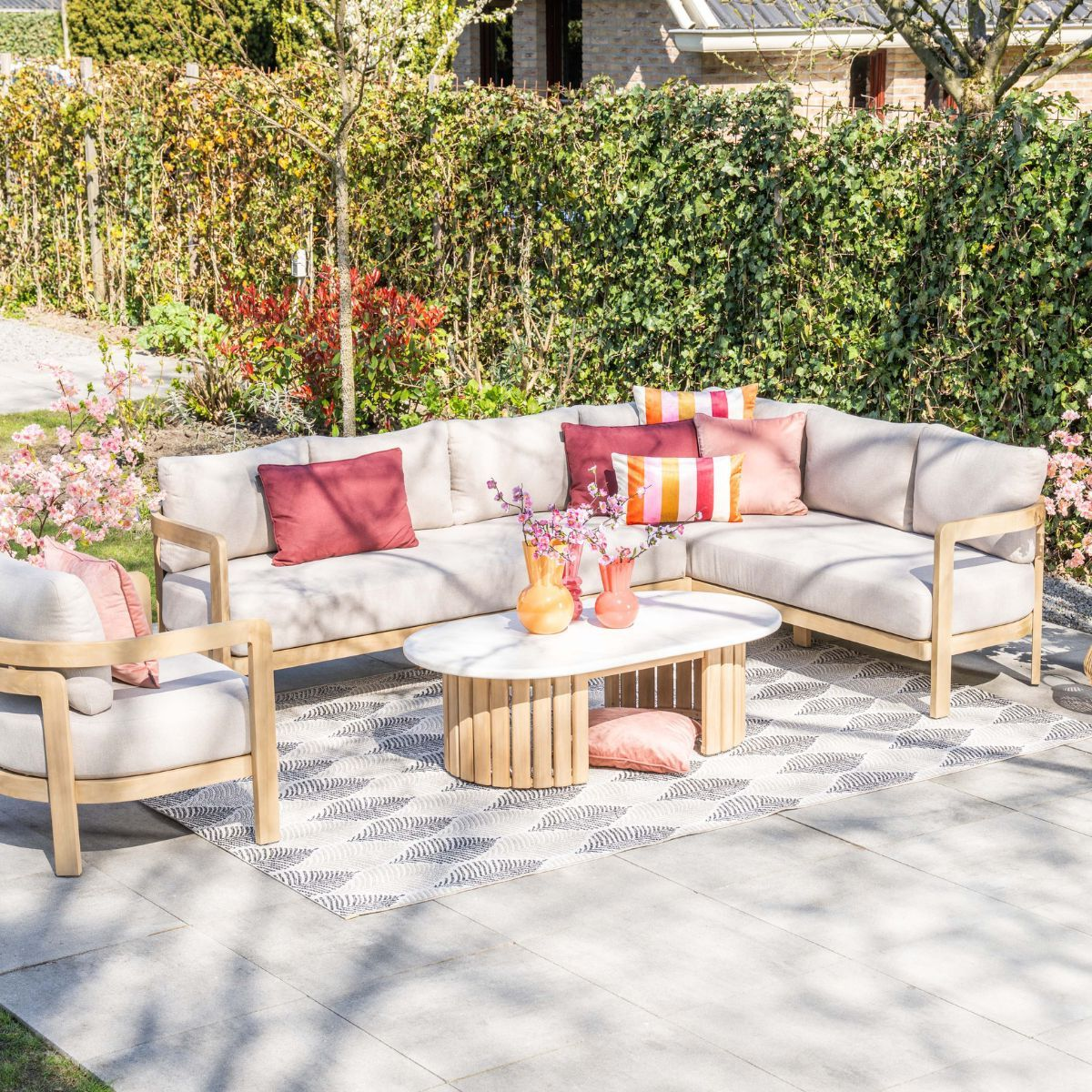 Een modulaire loungeset met lichte kussens en kleurrijke accentkussens.