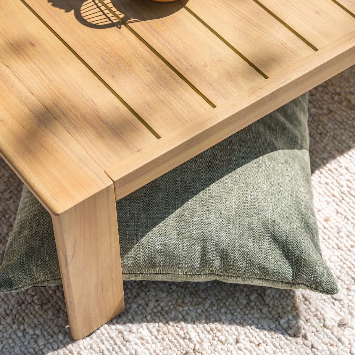 Een houten tafel rust op een groen kussen op een kleed.