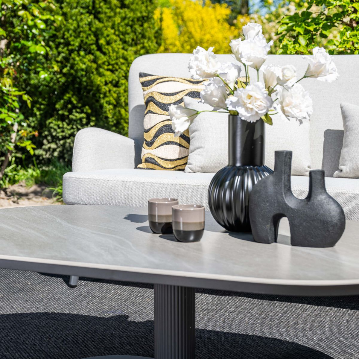 Grijze tafel met decoraties en bank op de achtergrond.