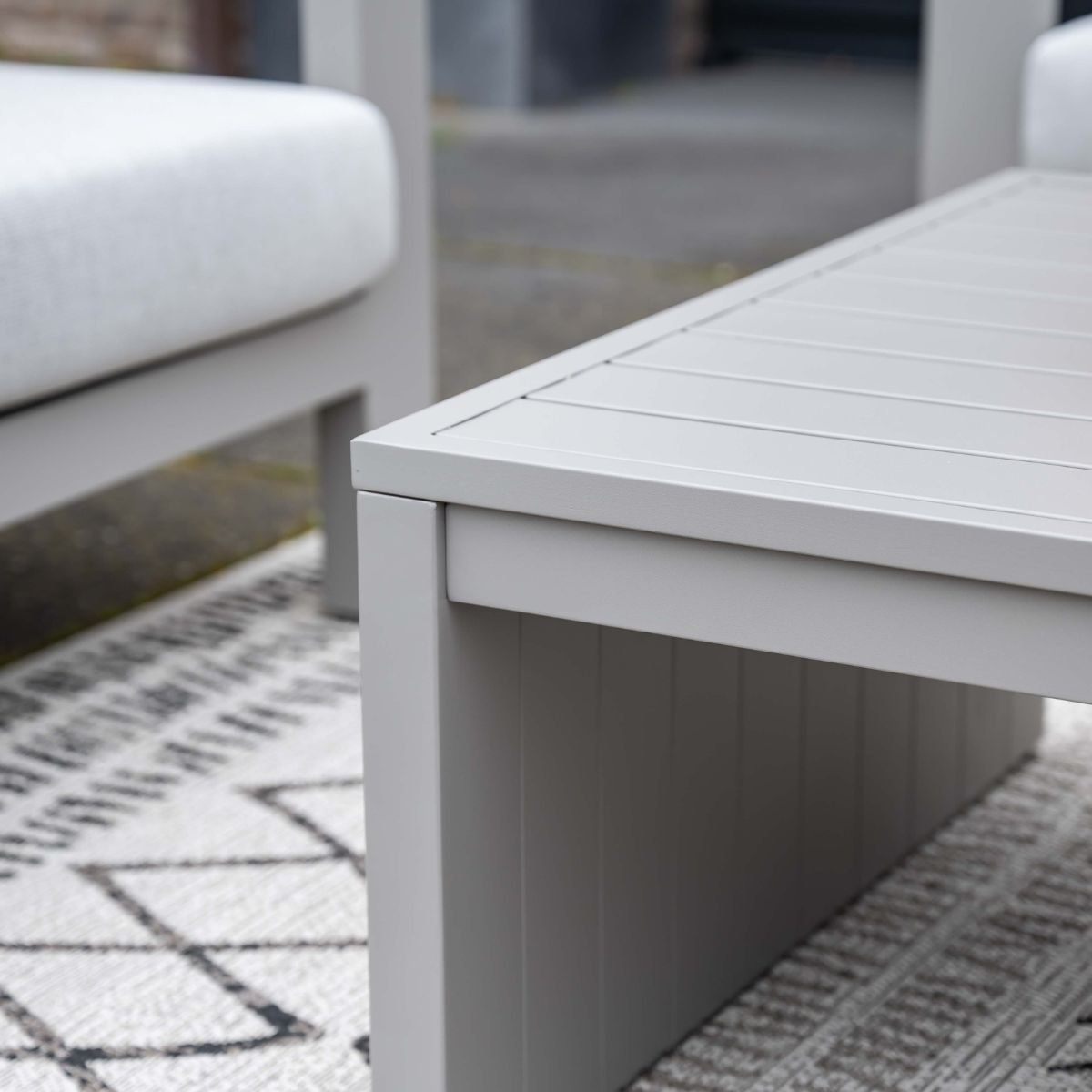 A grey slatted-top coffee table sits on a rug.