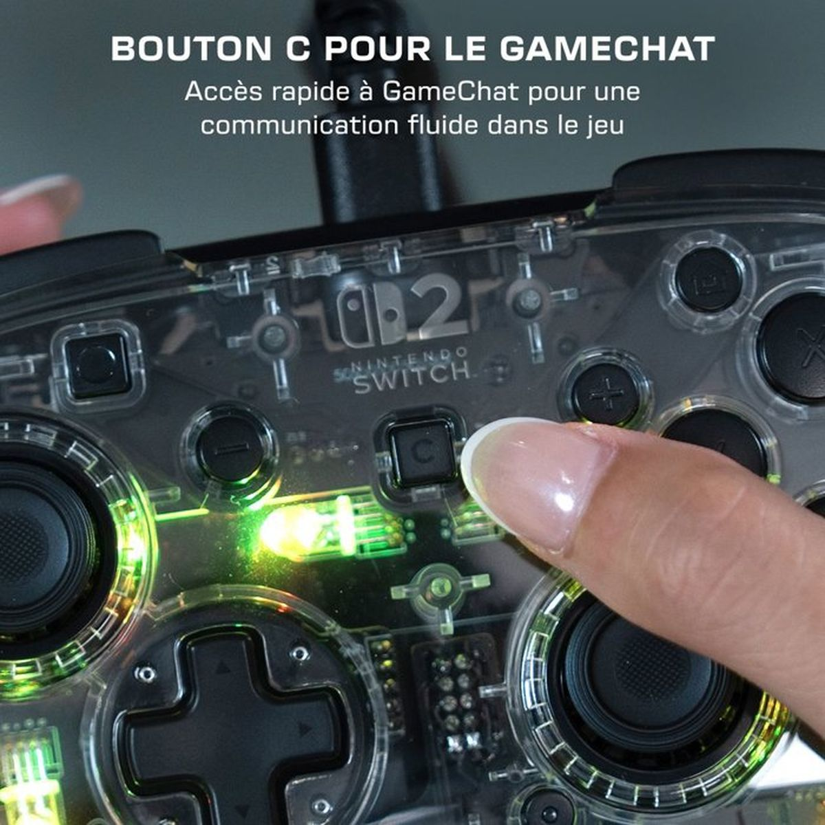 Un dito preme il pulsante C su un controller trasparente Nintendo Switch con illuminazione verde.