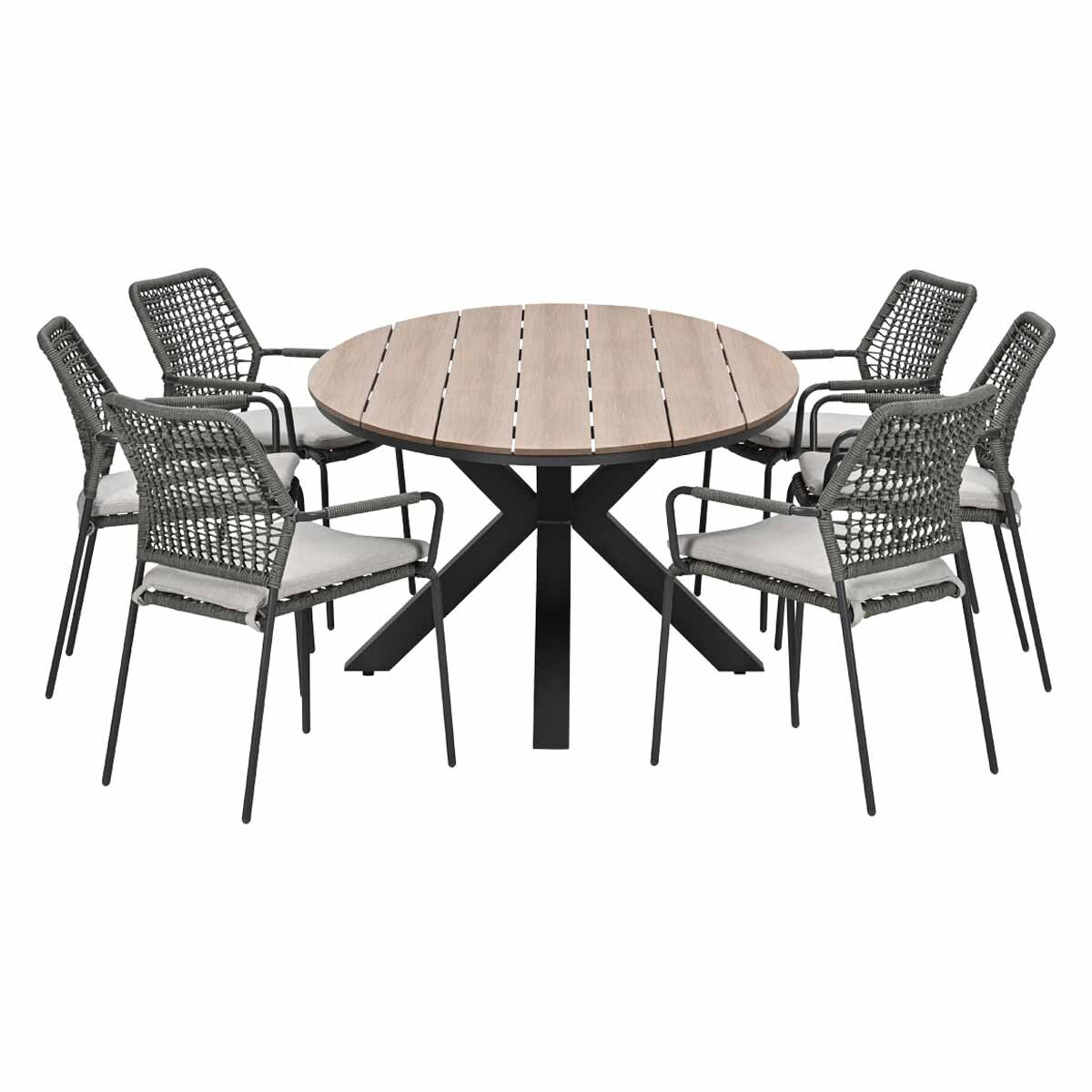 Ronde houten eettafel met zes grijze rotan stoelen met kussens.