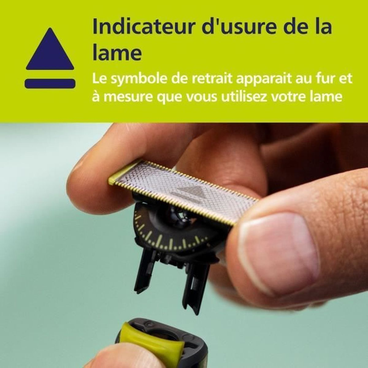 Una mano sostiene un cabezal de afeitadora con indicador de desgaste.