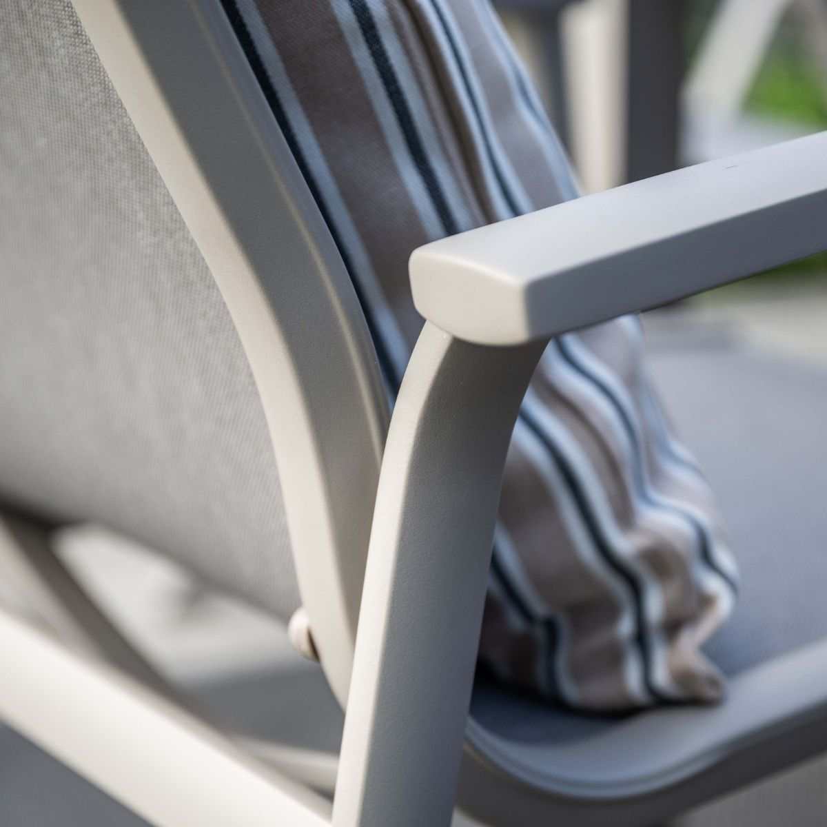 Grijze stoel met gestreept kussen, close-up van frame.