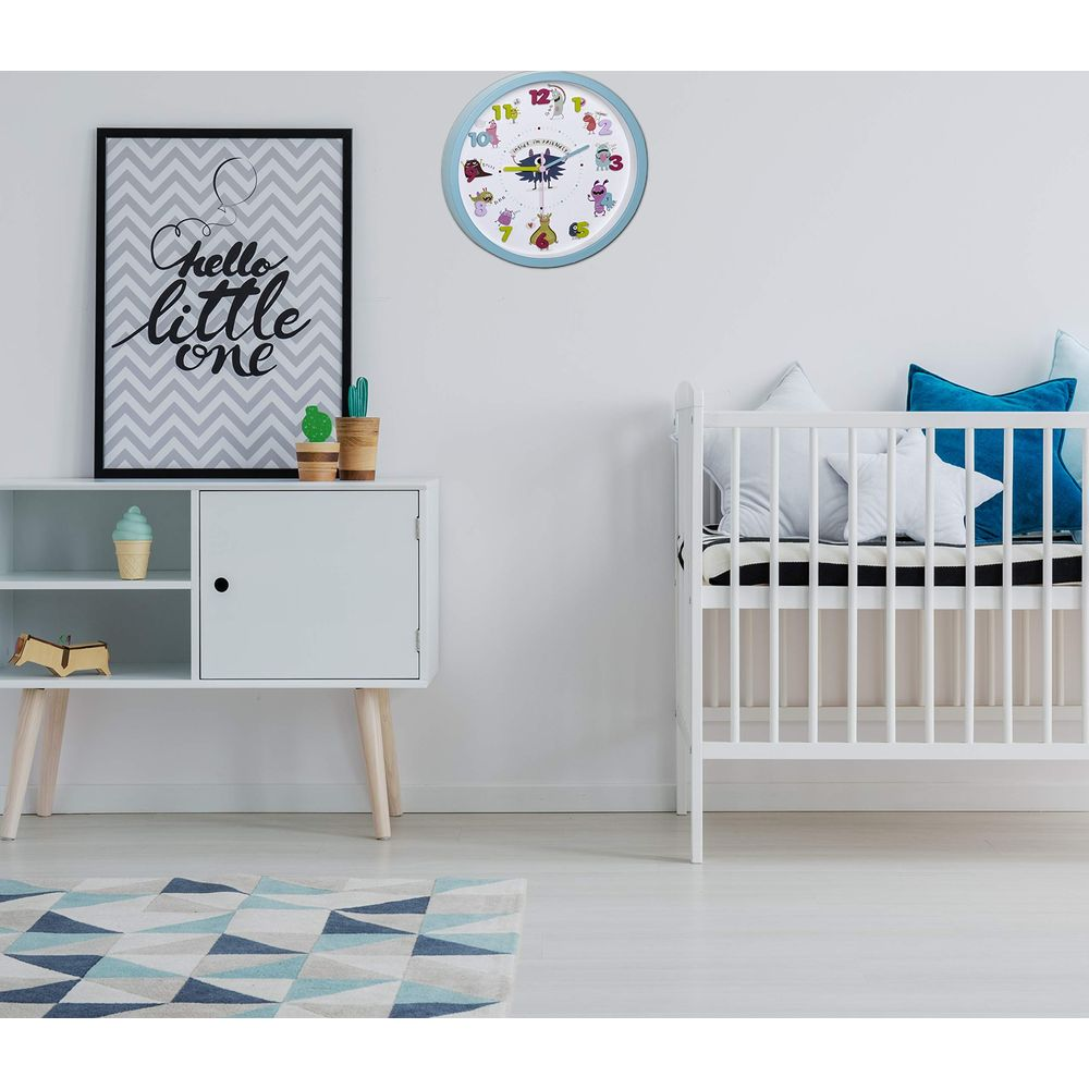 Ein Kinderzimmer mit einem Kinderbett, einer Kommode und einer Wanduhr mit Tiermotiven.