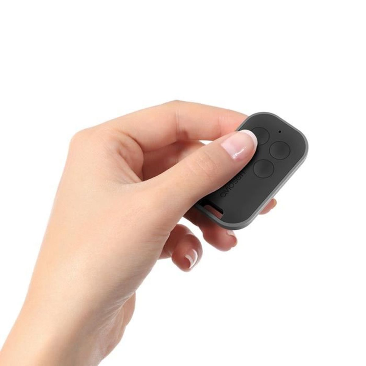 Una mano sostiene un mando a distancia gris con tres botones.