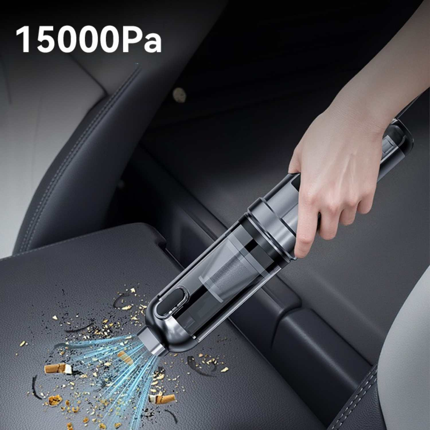 Hand saugt Krümel und Zigarettenstummel aus einem Autositz.