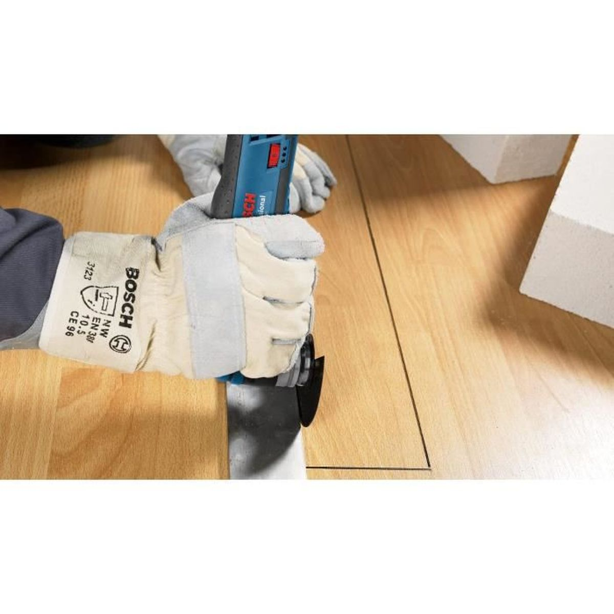 Person bearbeitet Holzboden mit blauem Bosch Werkzeug, trägt Handschuhe.