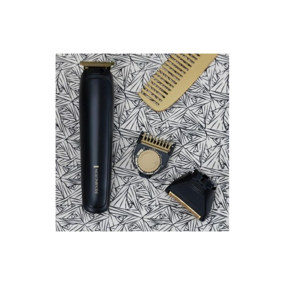 Schwarzer Remington-Trimmer mit goldenen Klingen, Kamm und Aufsätzen auf gemustertem Hintergrund.