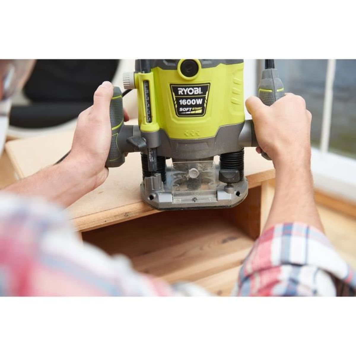 Mann bearbeitet Holz mit einem gelben Ryobi Router, Nahaufnahme.
