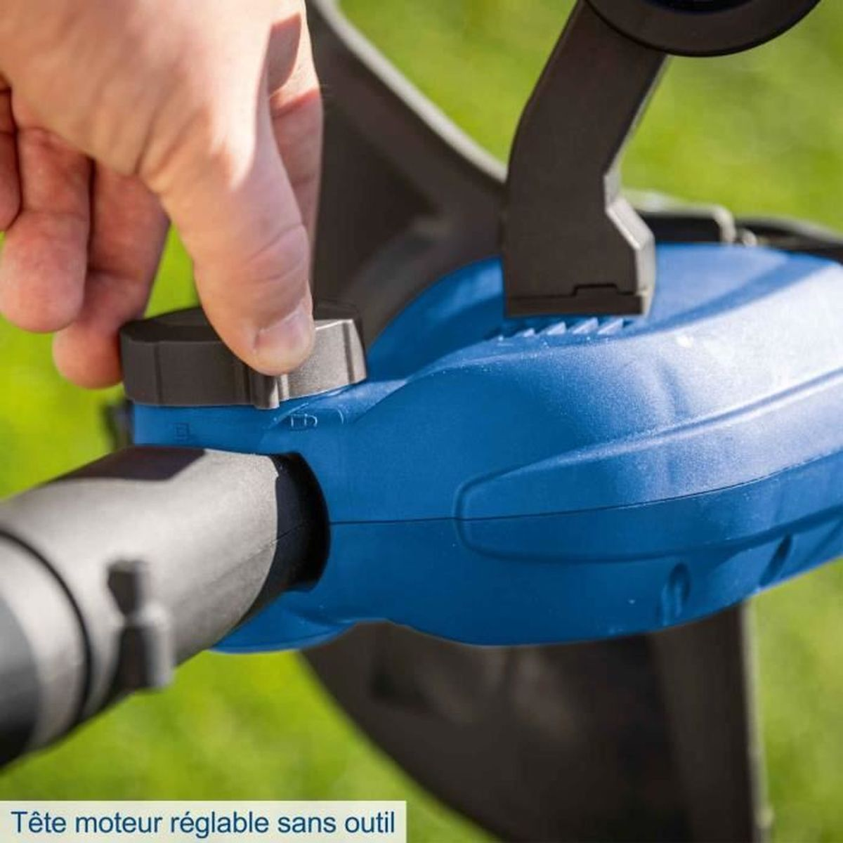 Eine Hand dreht einen Knopf an einem blauen Gerät im Freien auf grünem Gras.