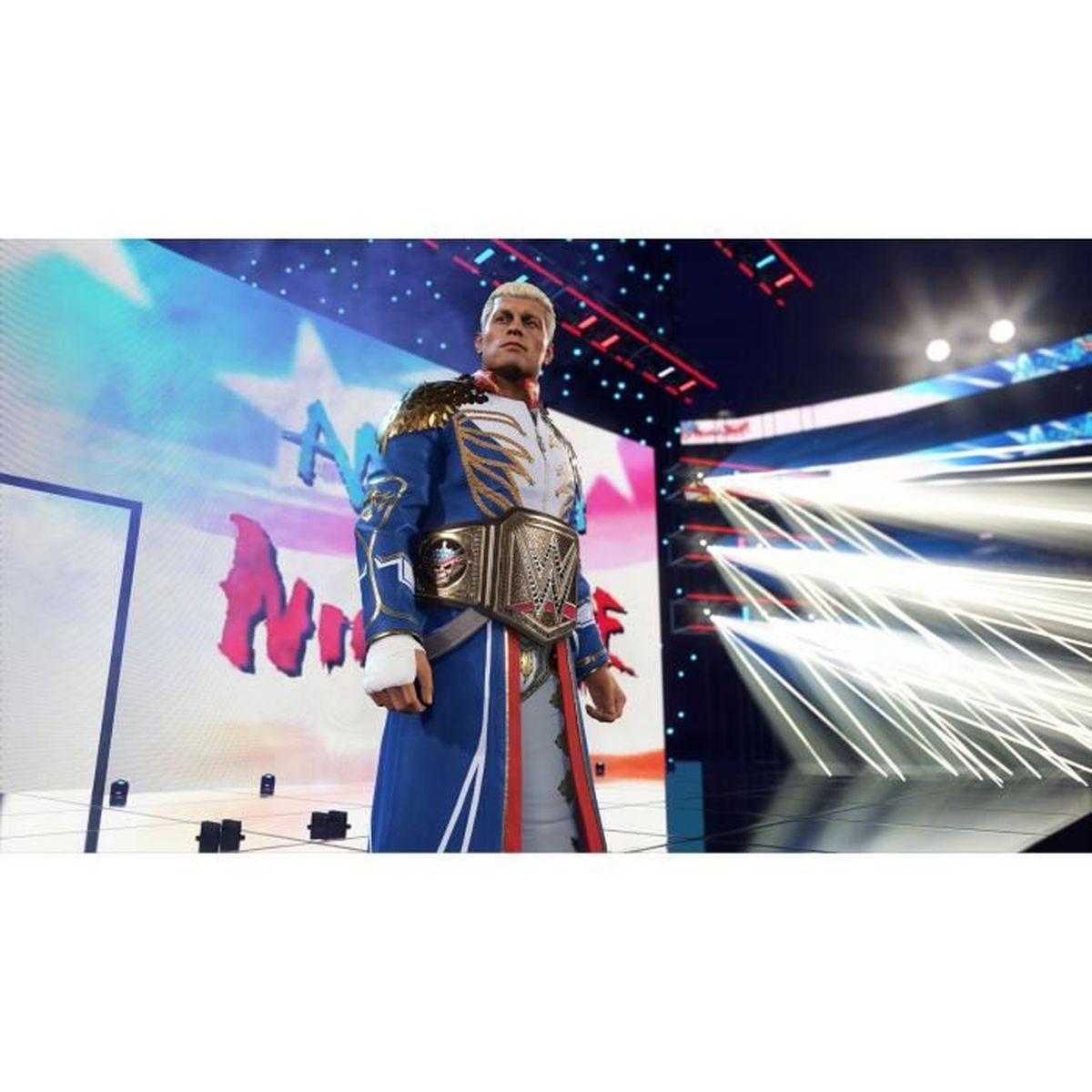 Un wrestler in uniforme blu con finiture dorate e cintura da campionato sta davanti a uno schermo.