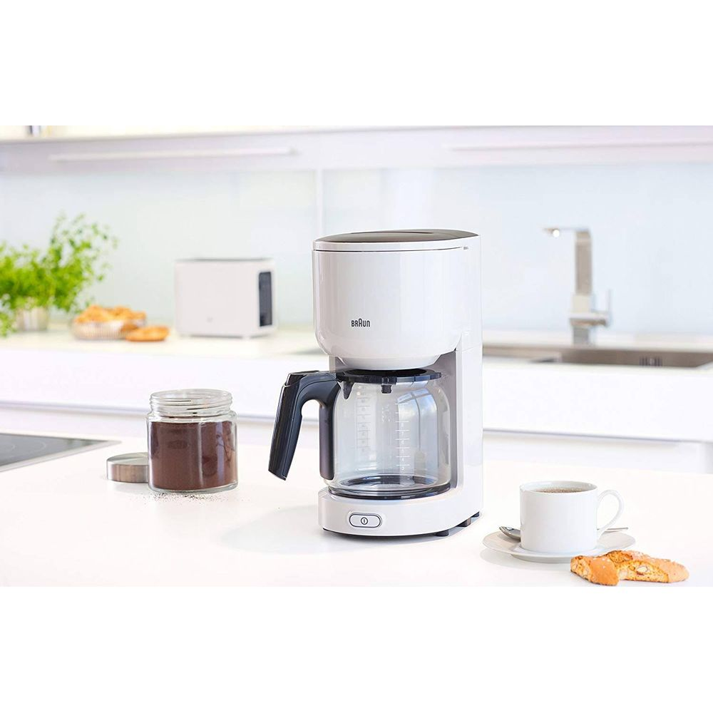 Biały ekspres do kawy z szklanym dzbankiem, filiżanką i słoikiem kawy.