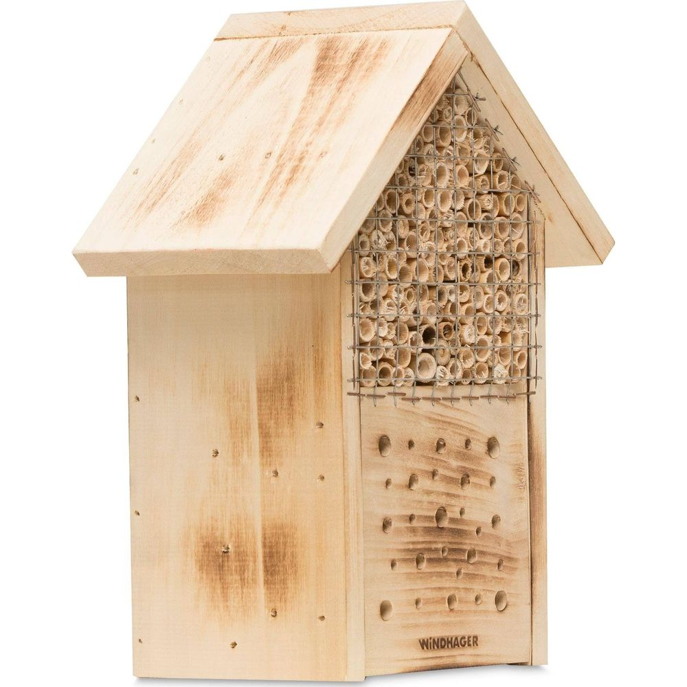 Un hotel per insetti in legno con tubi di bambù e fori.