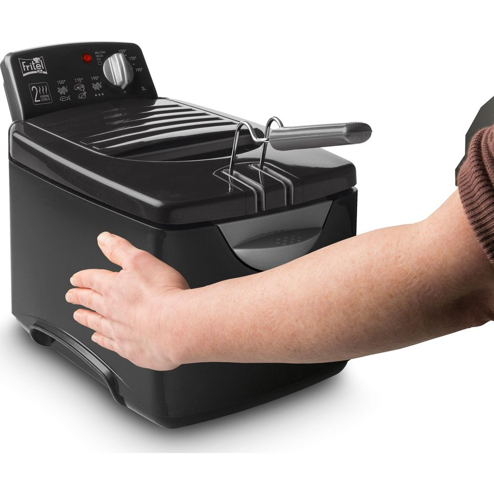 Een hand houdt een zwarte frituurpan met een zilveren handvat vast. De temperatuurknop is zichtbaar.