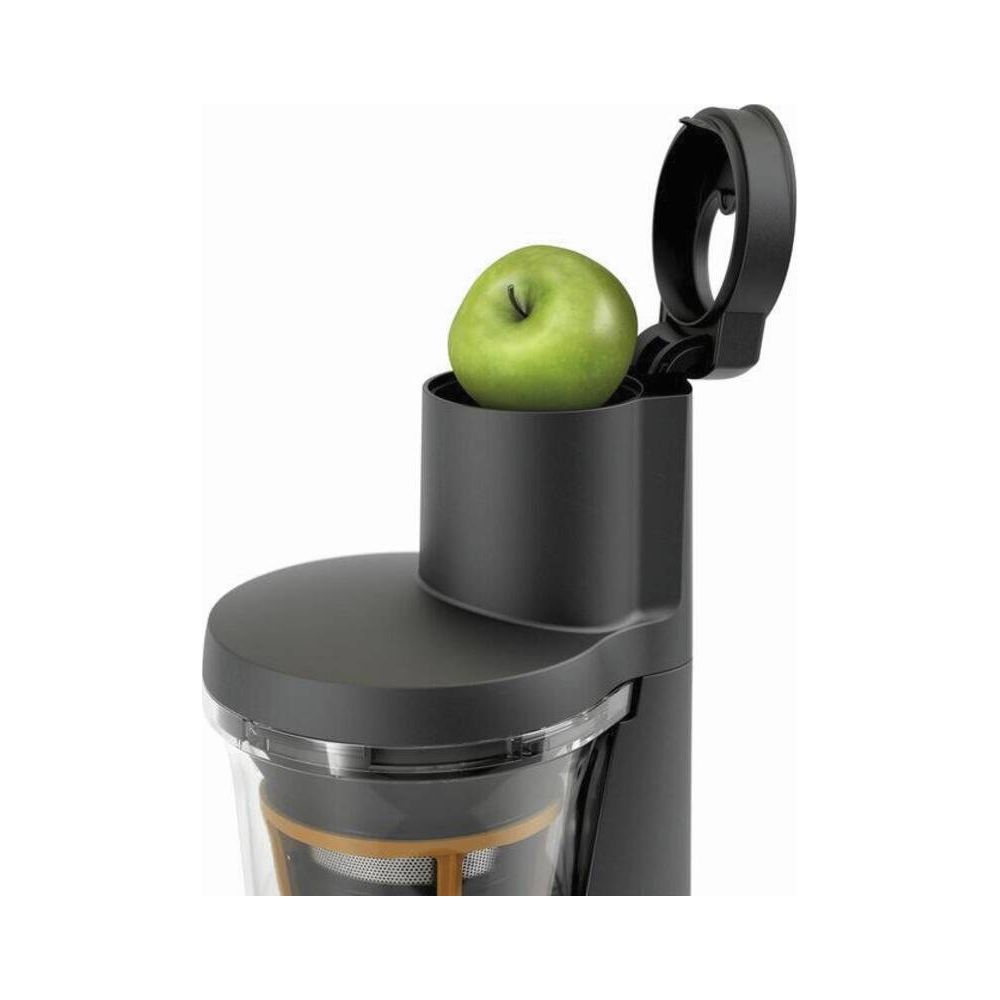 Ein grüner Apfel in einem schwarzen Entsafter.