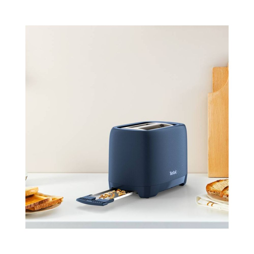 Ein blauer Tefal-Toaster mit Toast und Krümeln auf der Arbeitsplatte.