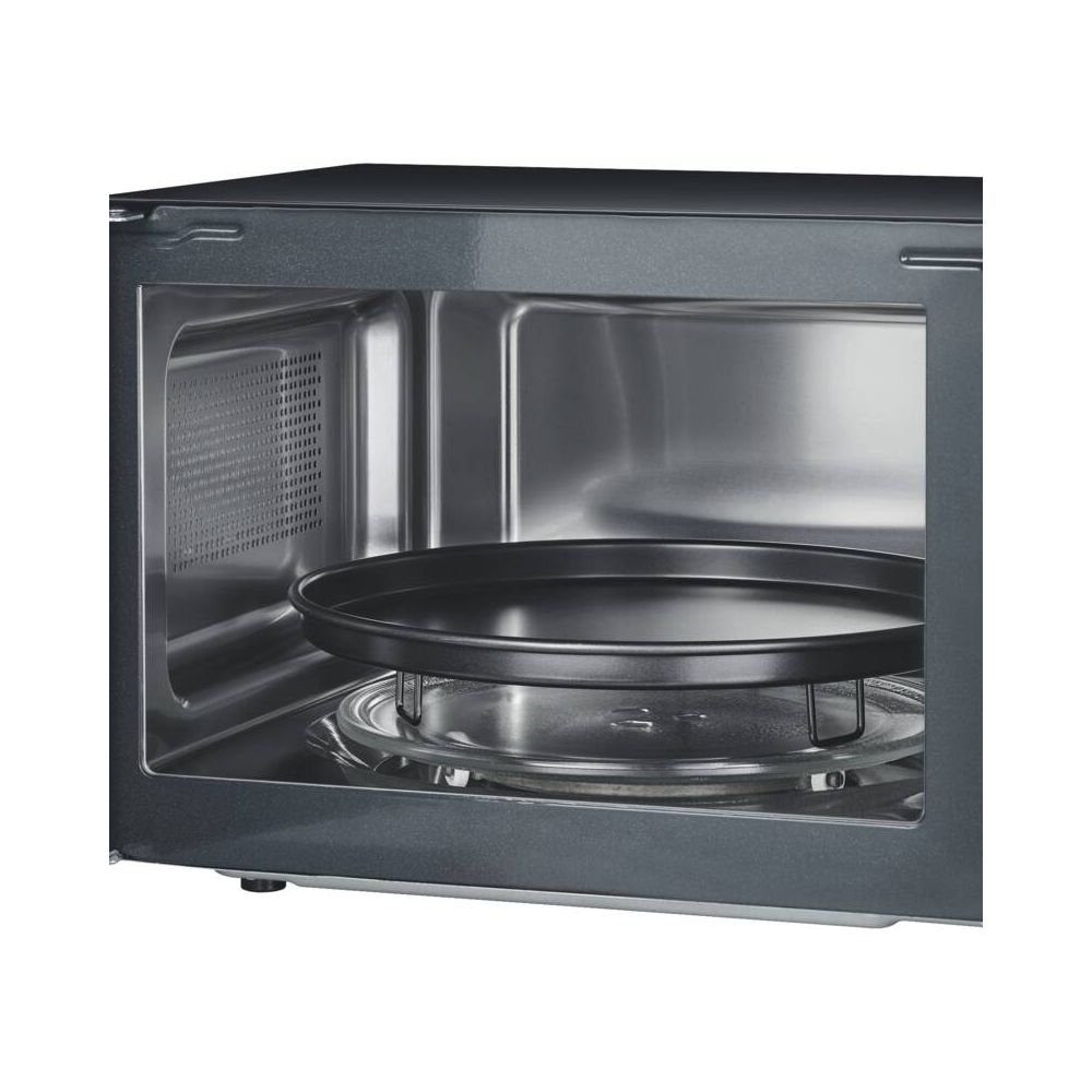 Wnętrze kuchenki mikrofalowej z obrotowym talerzem i rusztem.