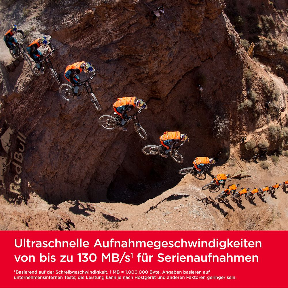 Meerdere mountainbikers in oranje uitrusting rijden een rotsachtige helling af.