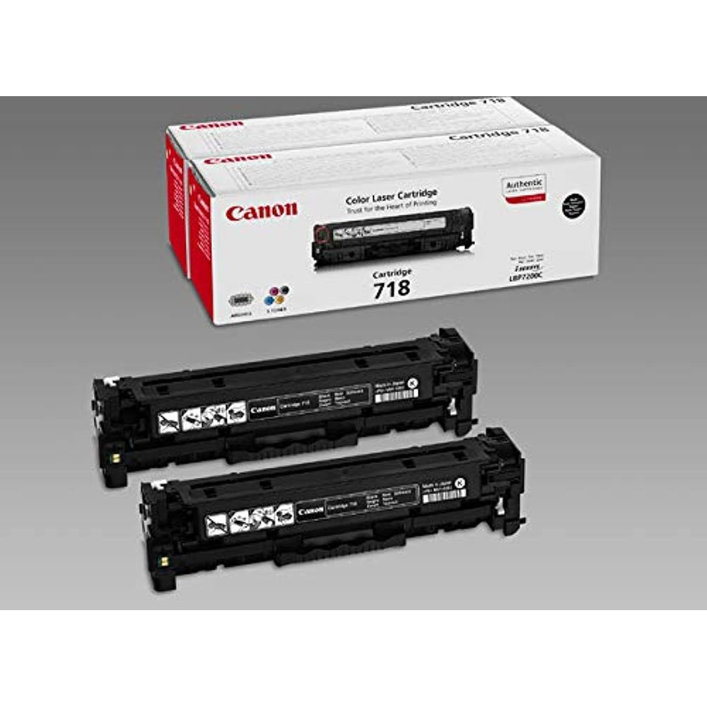 Dwa czarne wkłady laserowe Canon 718 przed otwartym pudełkiem.