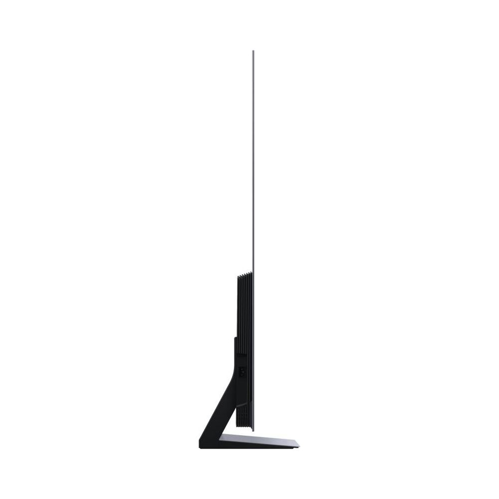 Un téléviseur noir et fin avec un pied étroit, vu de côté.