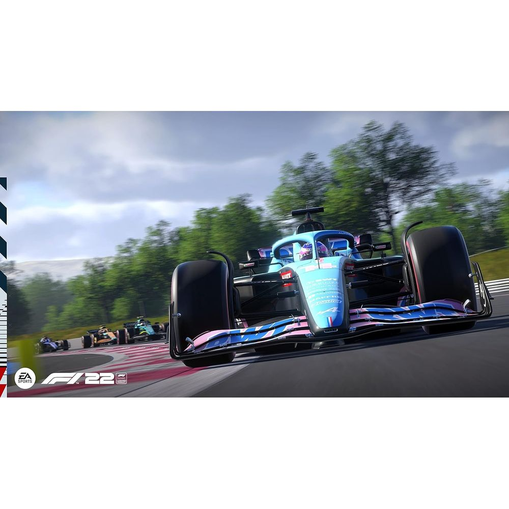 Un'auto di F1 blu e rosa corre su una pista con altre auto e alberi sullo sfondo.