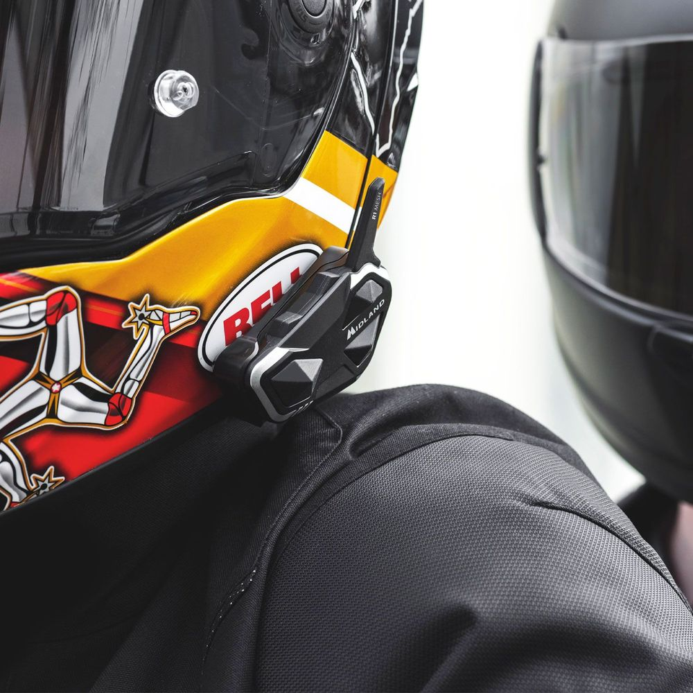 Zbliżenie na motocyklistę w zestawie słuchawkowym i kasku żółto-czerwonym.