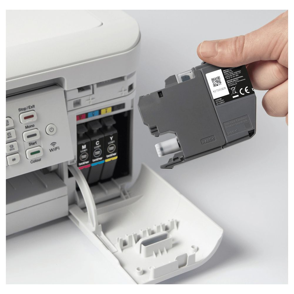 Dłoń wkłada szary wkład atramentowy do otwartej drukarki z widocznymi kolorowymi wkładami.