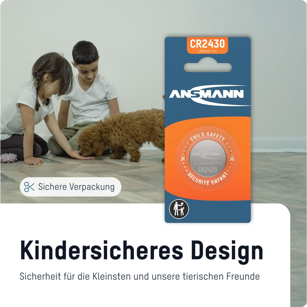 Dwoje dzieci i pies bawią się na podłodze obok opakowania baterii.