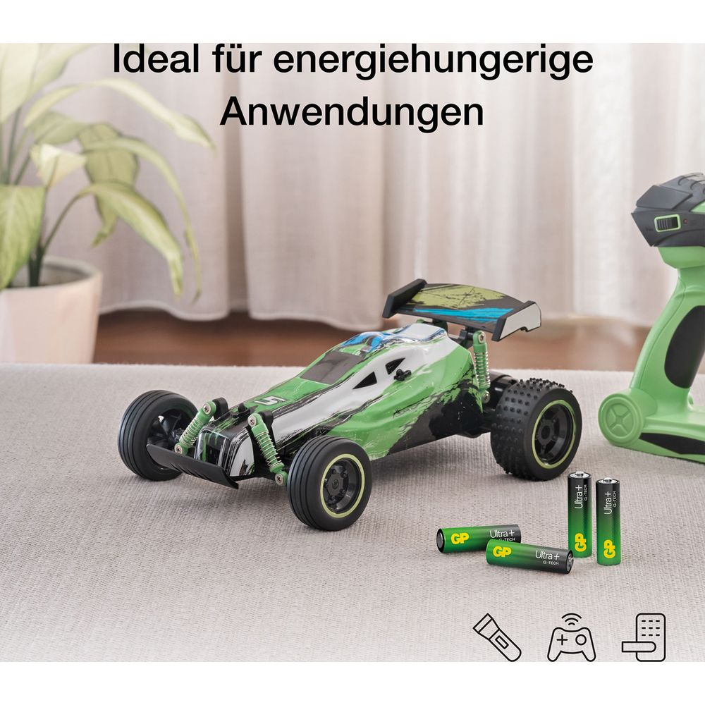 Ein grünes RC-Auto mit Batterien und Fernbedienung auf einem Teppich.