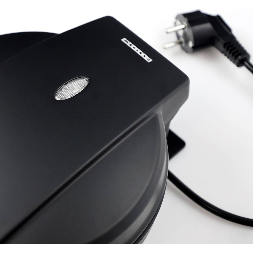 Black waffle maker with a power plug on a white background.