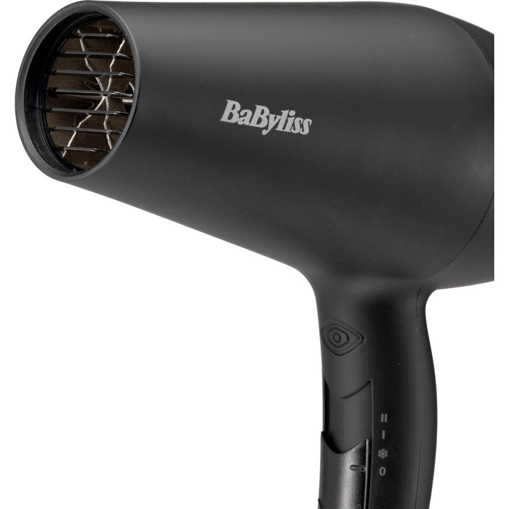 Un asciugacapelli Babyliss nero con griglie argentate sul davanti e controlli.