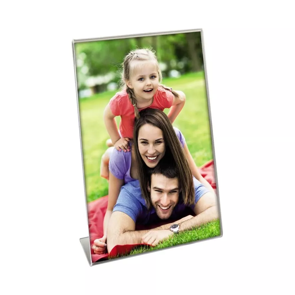 Familie, Vater, Mutter und Kind, die im Freien auf einer Decke liegen und lächeln.