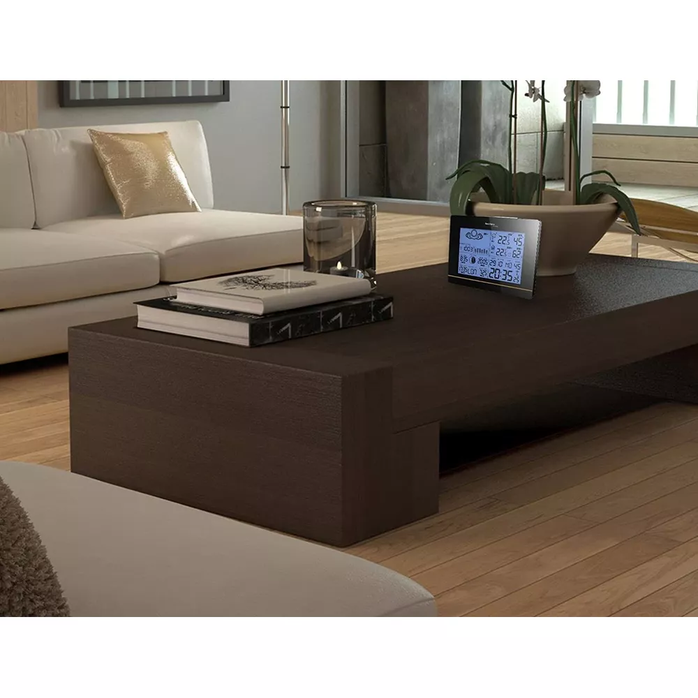 Une table basse de salon moderne avec une station météo numérique.