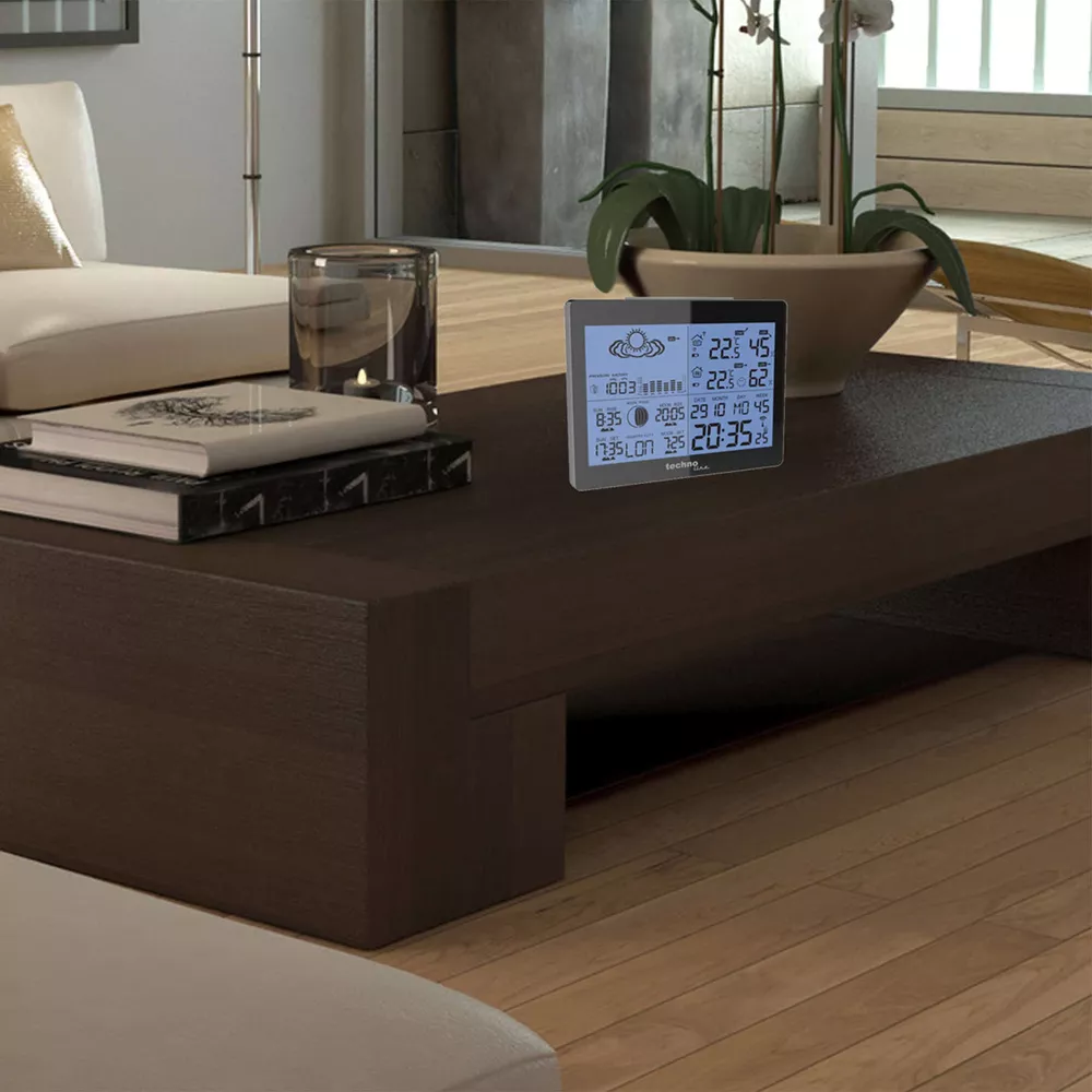 Horloge numérique sur table en bois affichant météo et heure.