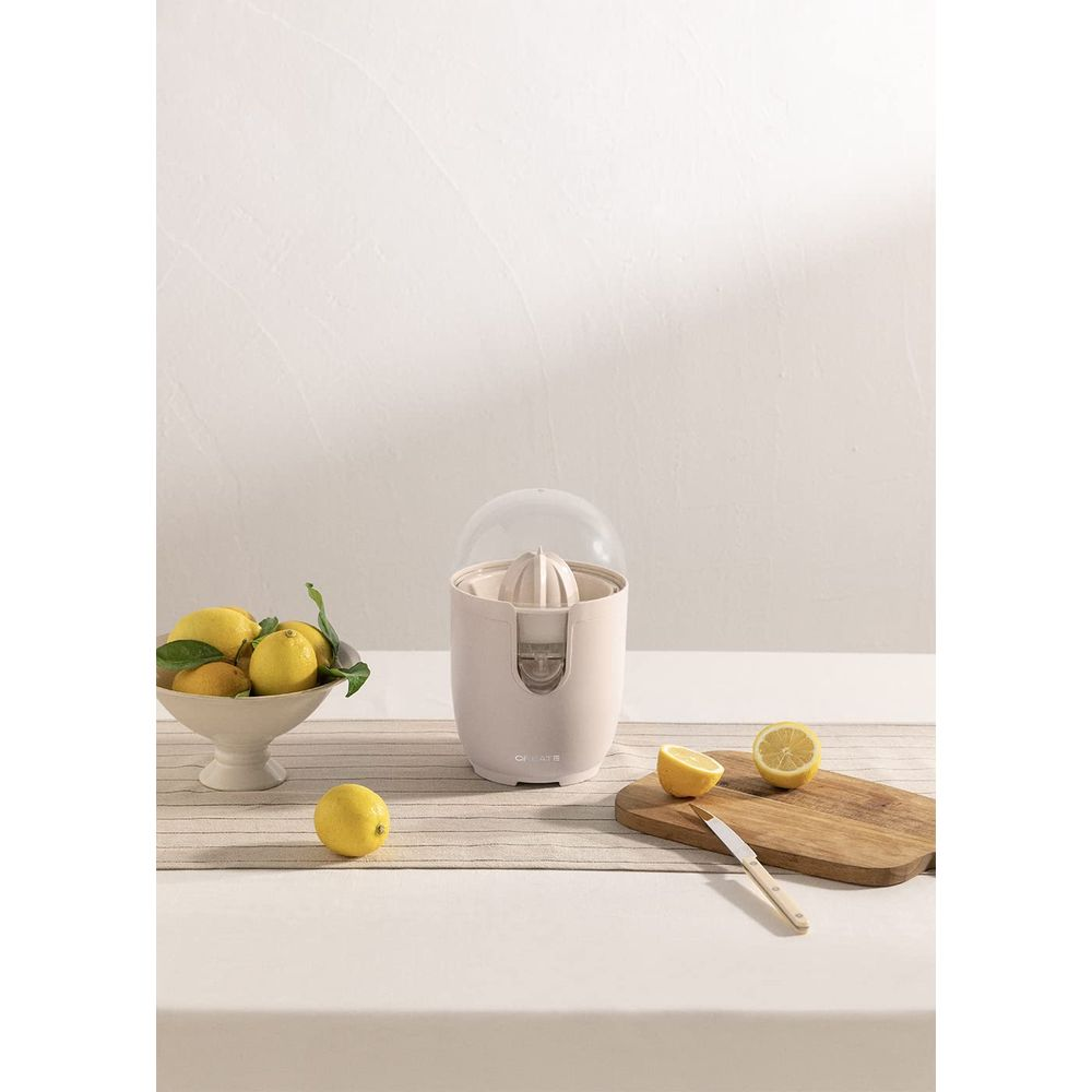 Un exprimidor de cítricos con limones en un cuenco y en una tabla de cortar.