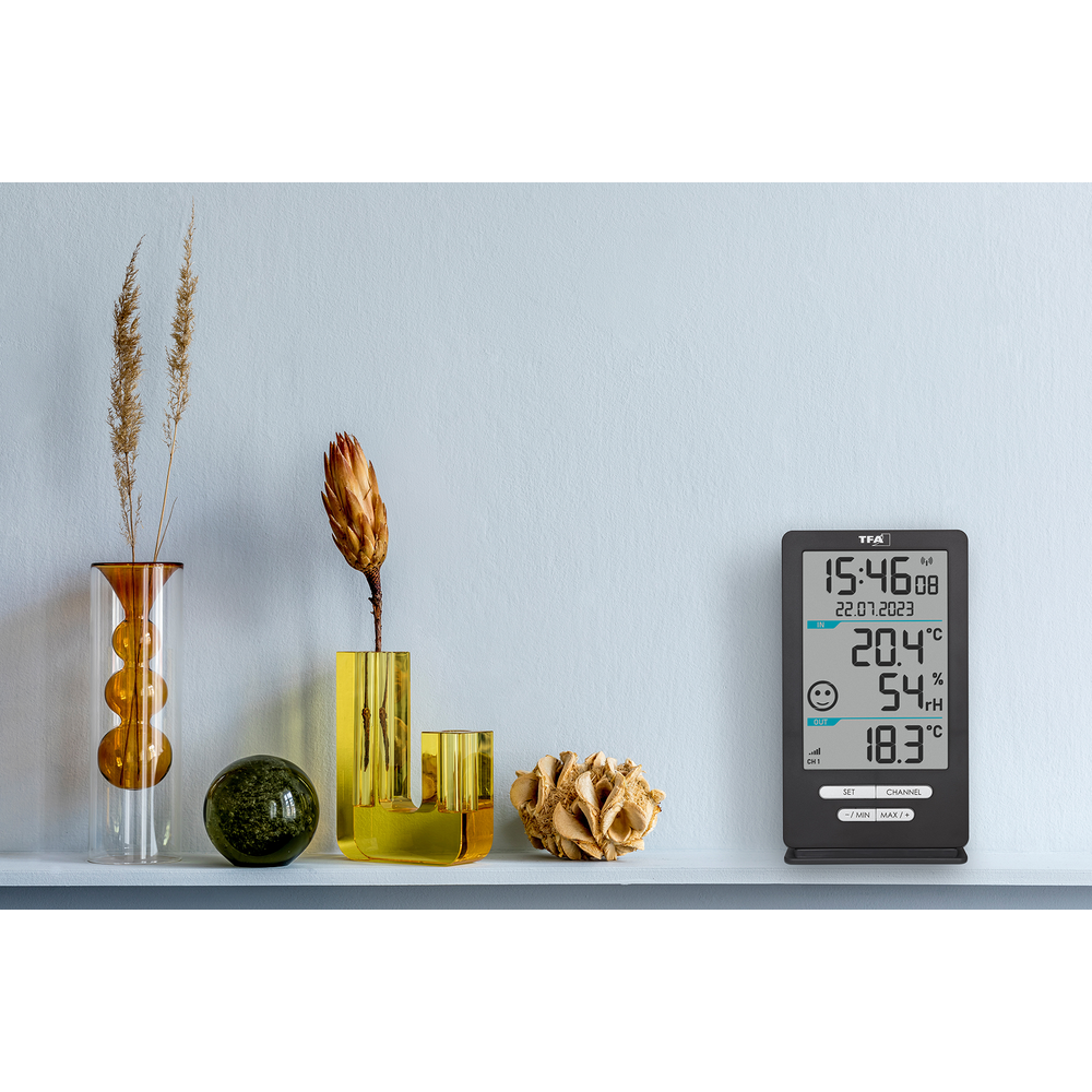 Ein Thermometer zeigt 20.4°C und 54% Luftfeuchtigkeit an. Zwei Vasen mit Trockenblumen.