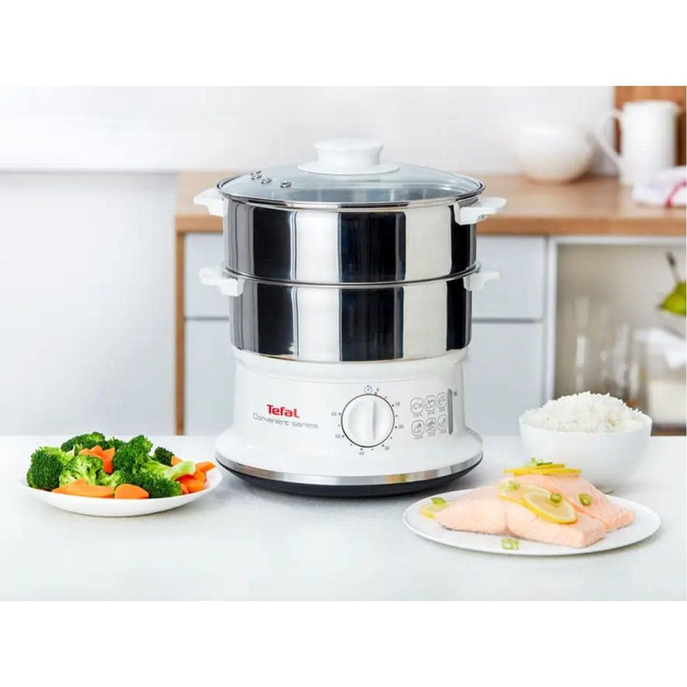 Una vaporera Tefal blanca de dos niveles, junto a salmón, arroz y verduras.
