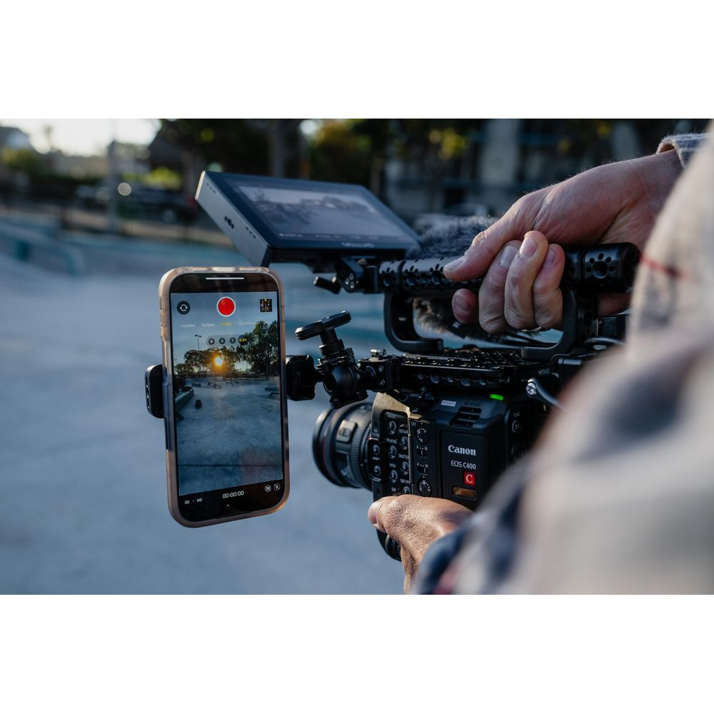 Mężczyzna trzyma kamerę wideo z uchwytem na telefon i smartfonem.