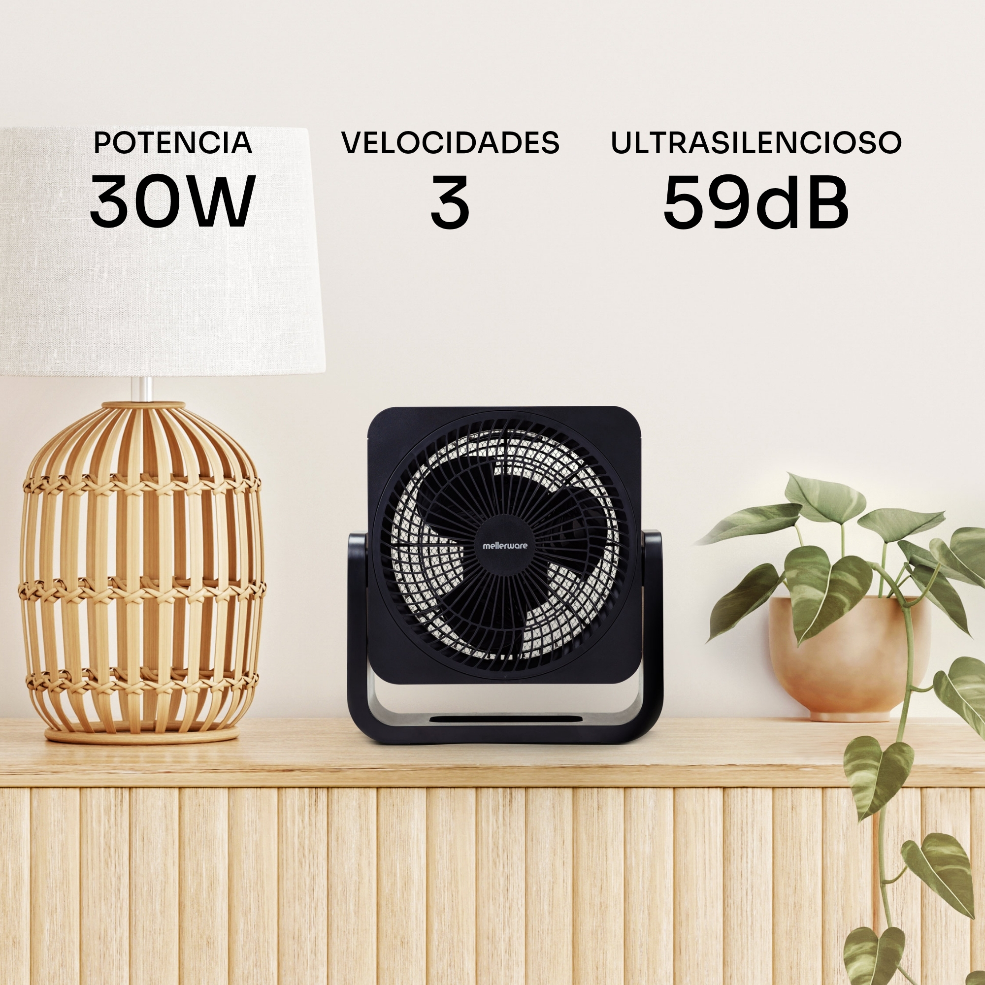 Un ventilador negro está sobre un mueble de madera junto a una lámpara y una planta.